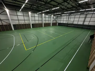 Sală multisport interioară cu marcaje pentru baschet, volei și handbal